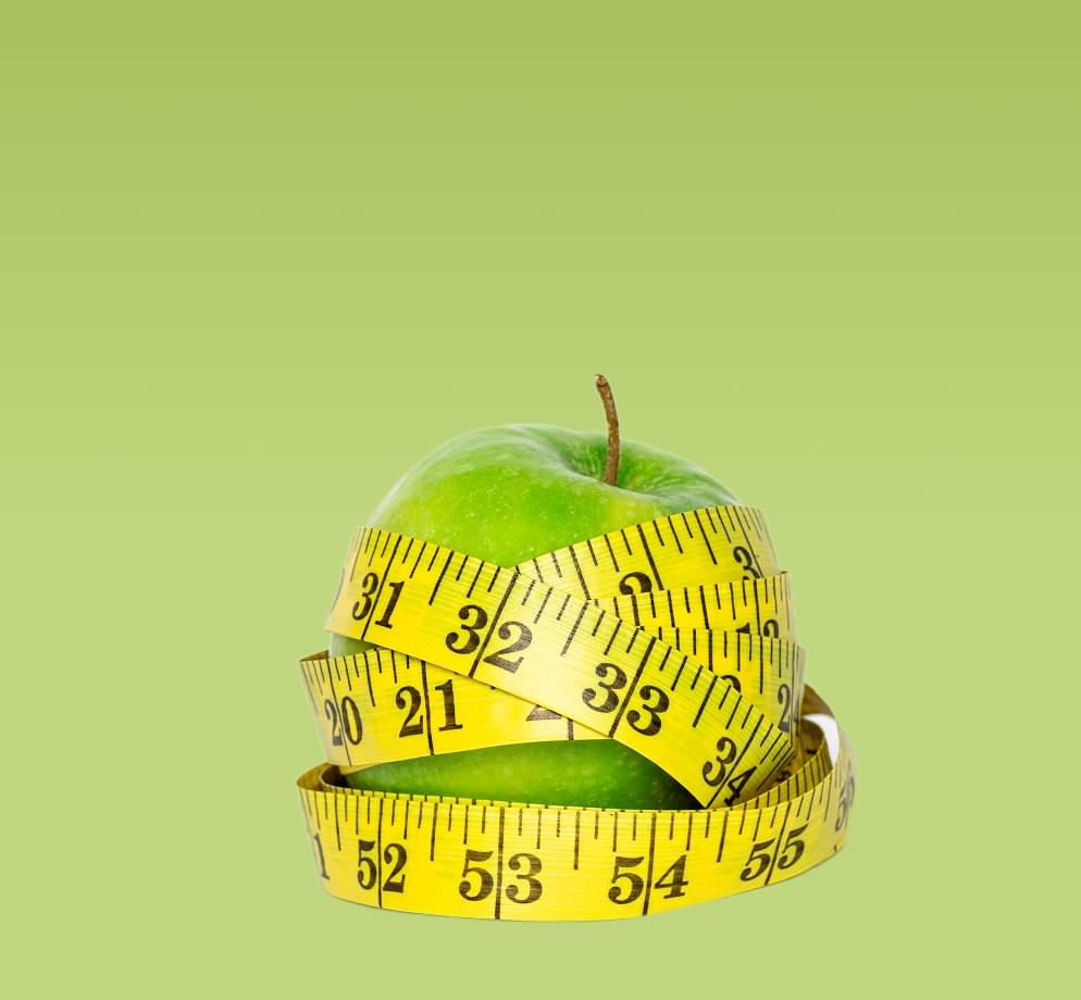 Картинка зеленого яблока, обмотанного мерной лентой